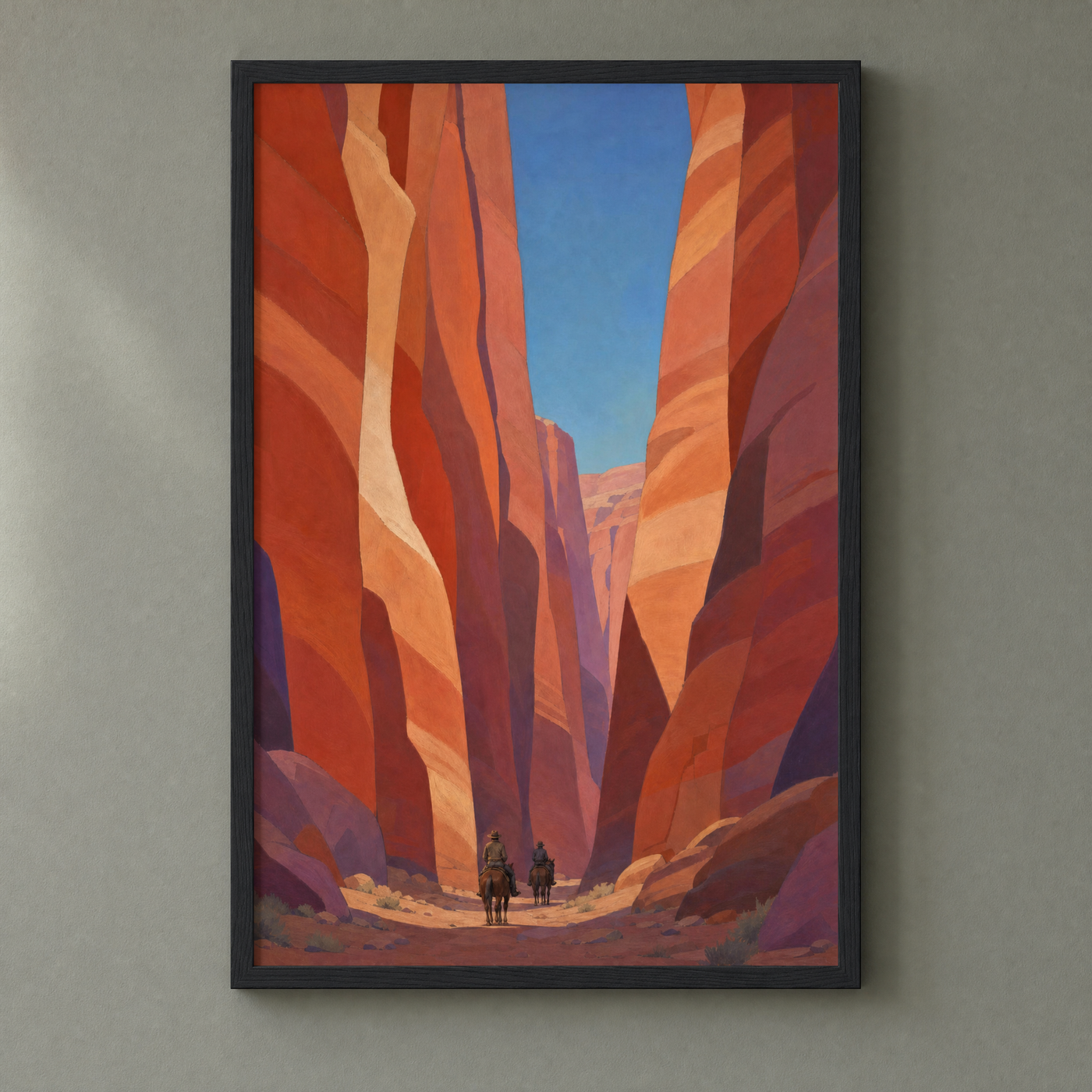 Canyon Riders framed print in a slim matte black frame on a sage-grey wall — riders beneath red canyon walls, ready to hang.