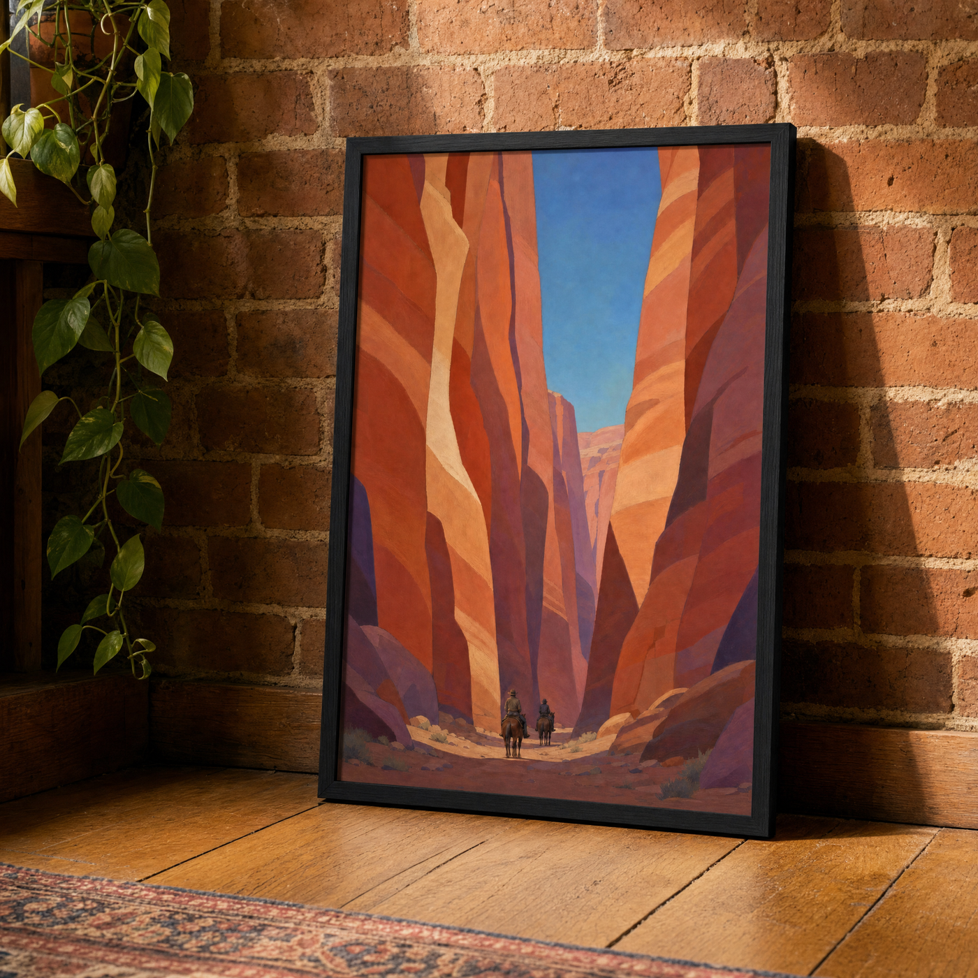 Canyon Riders framed print leaning against an exposed brick wall in a black frame.