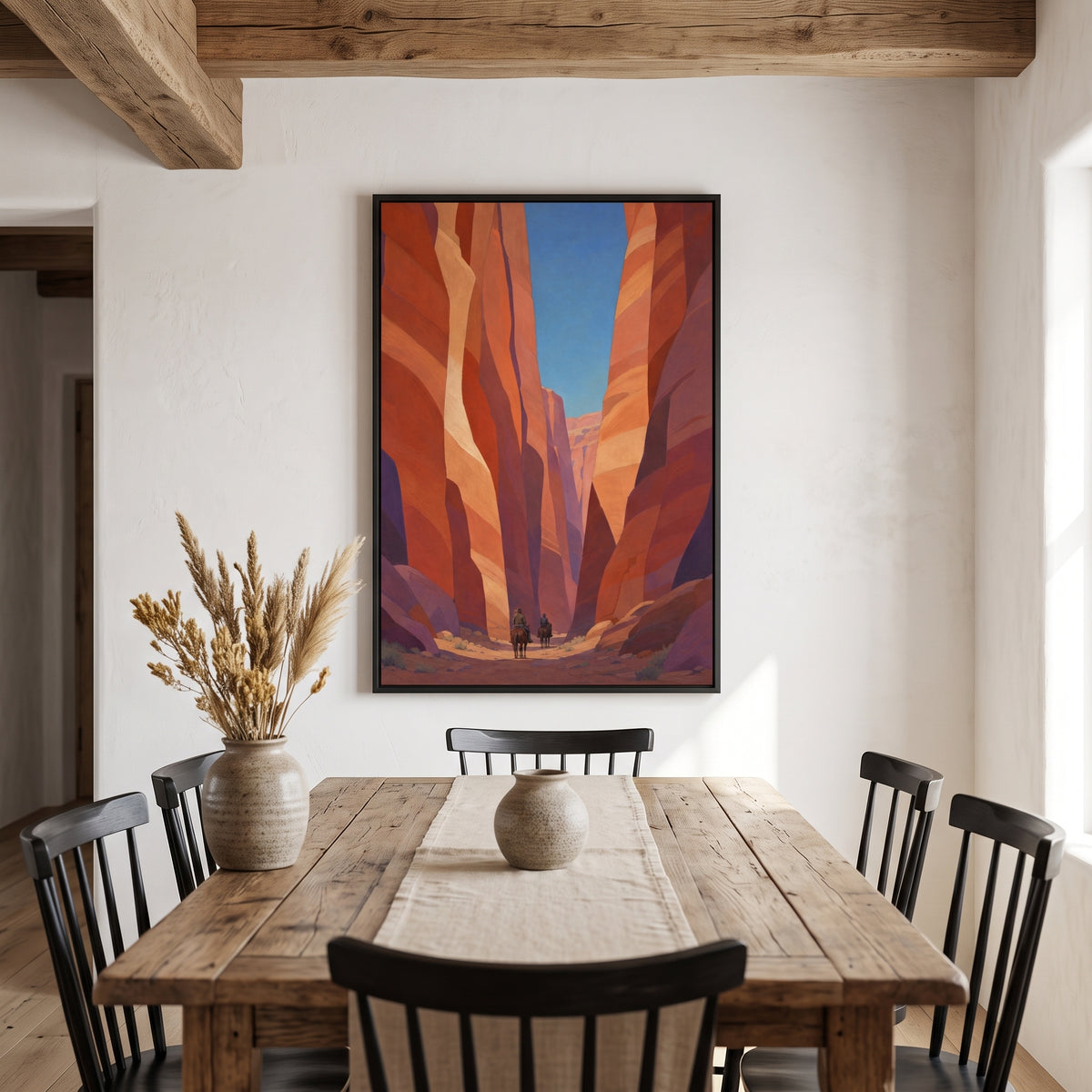 Canyon Riders framed print in a black frame at the end of a rustic dining table