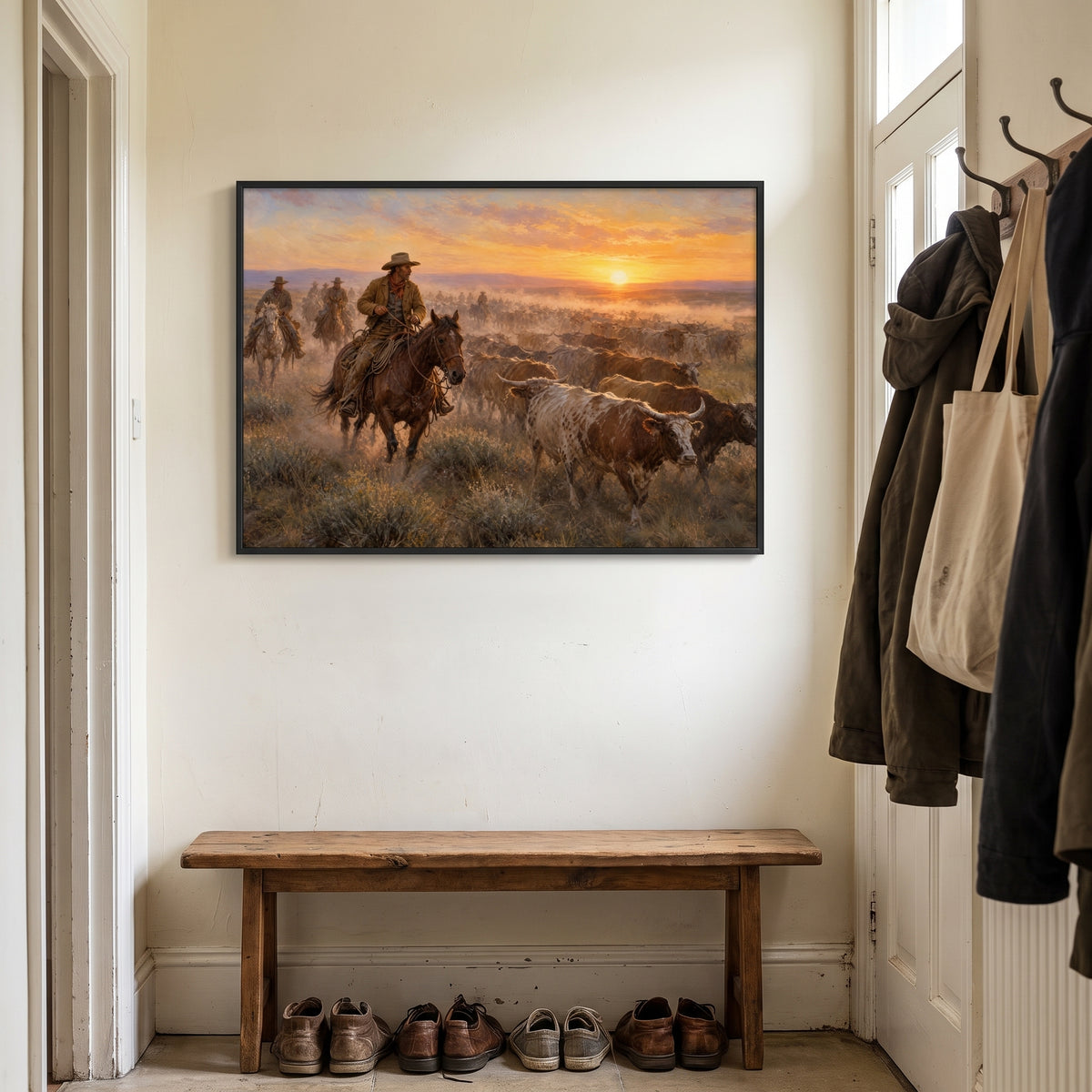 The Cattle Drive — Sunset: cowboys driving a longhorn herd across the prairie at sunset, western framed wall art above a wooden bench in a hallway