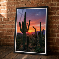 Desert Gold framed print, matte black frame, leaning against an exposed brick wall.