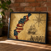 The Thirteen Colonies map print leaning against an exposed brick wall in a black frame.