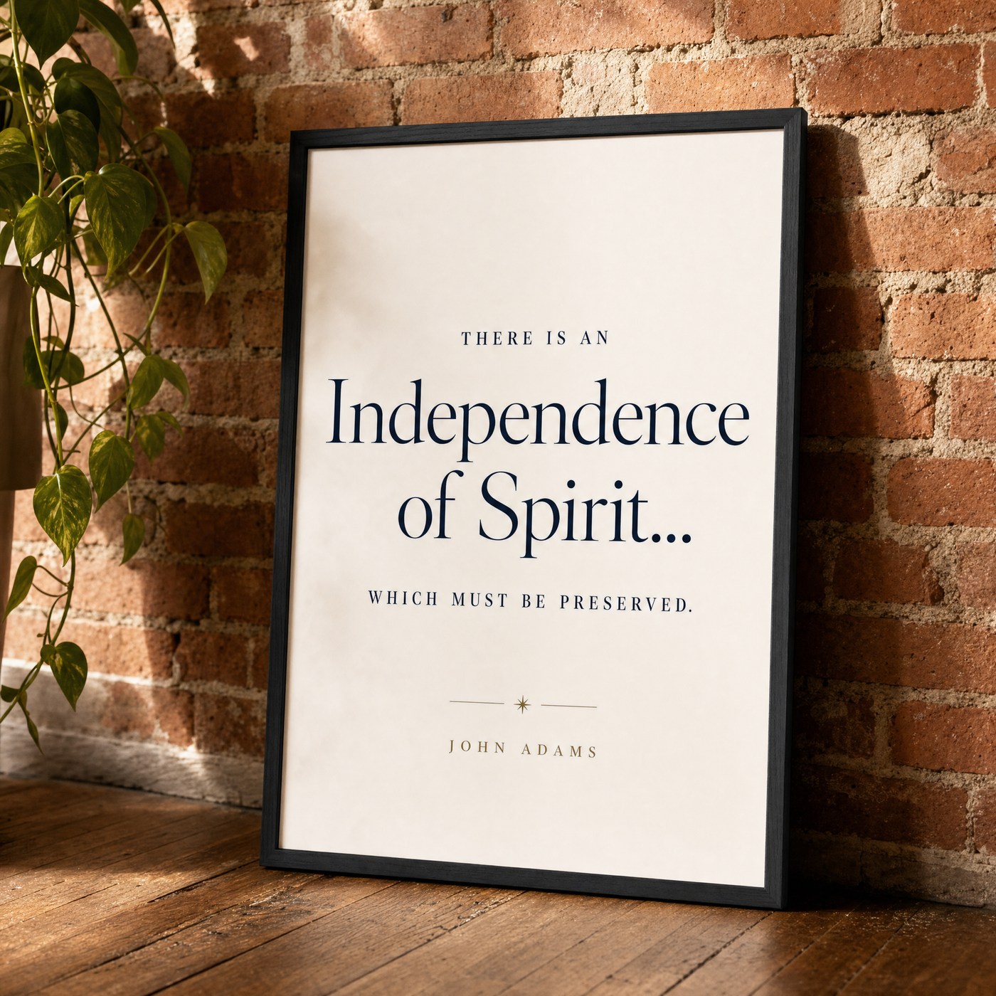Independence quote print leaning against an exposed brick wall in a black frame.