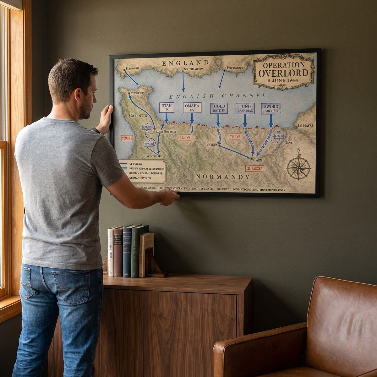 Man hanging the Operation Overlord — Map framed print on the wall