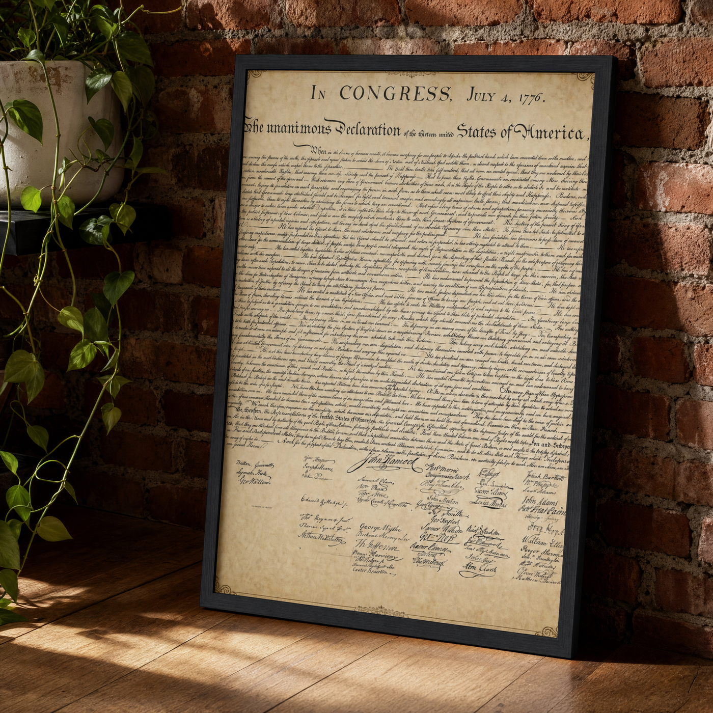 The Declaration of Independence framed print leaning against an exposed brick wall in a black frame.