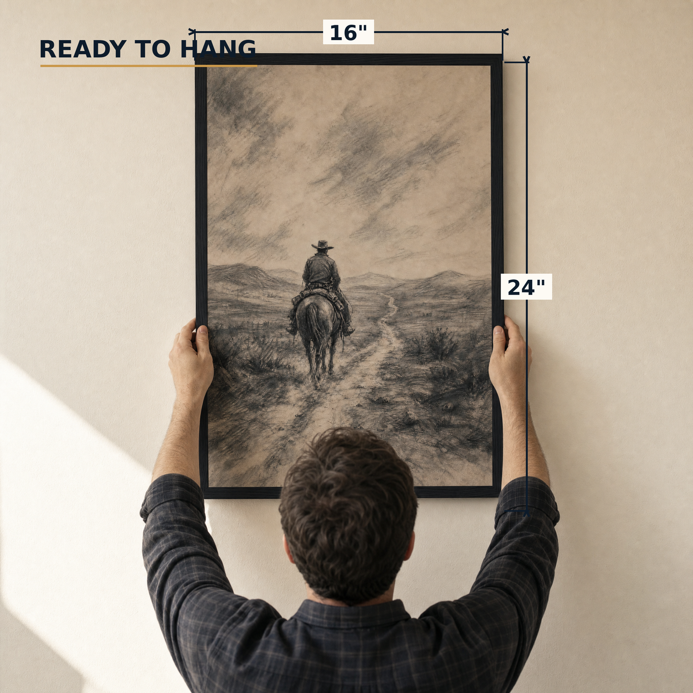 The Drifter framed charcoal print, matte black frame, 16×24″, held to the wall — ready to hang out of the box.