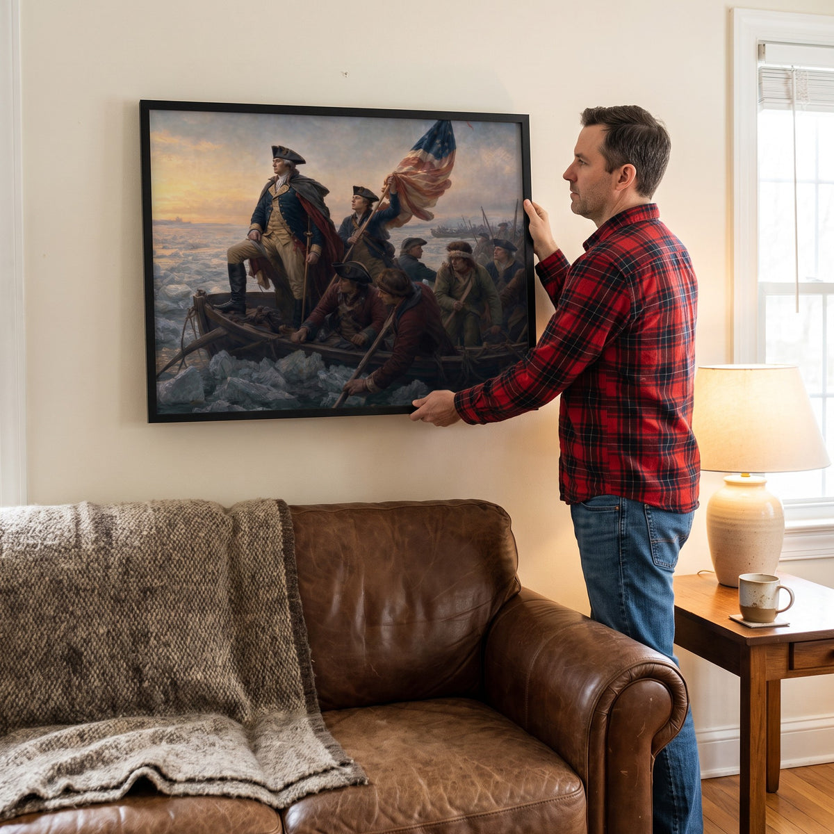 Man hanging the Washington Crossing the Delaware framed print on the wall