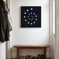 Vortex of America – white stars spiraling on a black ground, patriotic canvas wall art above a wooden bench in a hallway